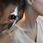 arzt untersucht patienten nach hautkrebs mit der lupe