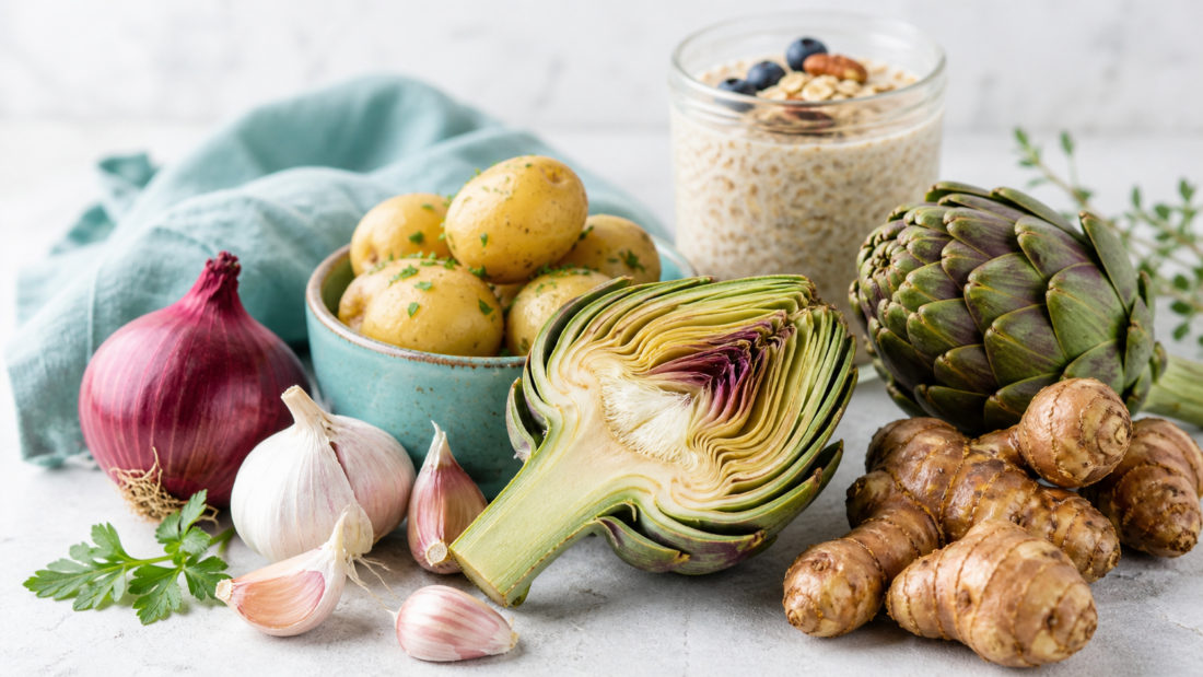 Auswahl ballaststoffreicher präbiotischer Lebensmittel wie Artischocken und Zwiebeln zur Unterstützung der Darmflora.