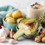 Auswahl ballaststoffreicher präbiotischer Lebensmittel wie Artischocken und Zwiebeln zur Unterstützung der Darmflora.
