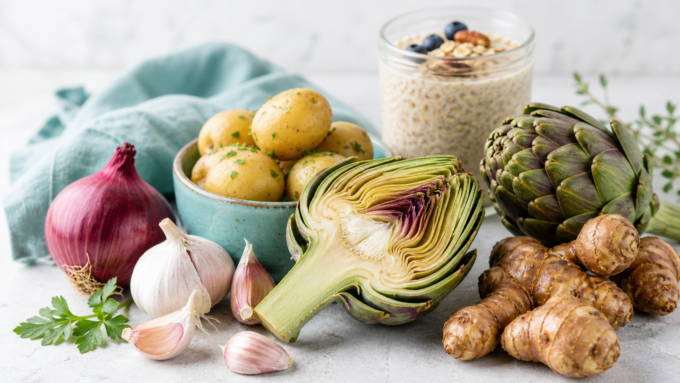 Auswahl ballaststoffreicher präbiotischer Lebensmittel wie Artischocken und Zwiebeln zur Unterstützung der Darmflora.